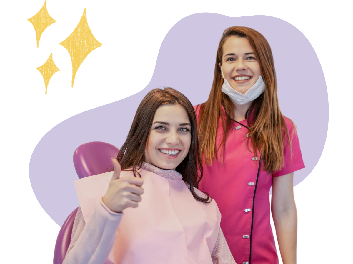 Happy dental patient giving a thumbs up beside a smiling hygienist